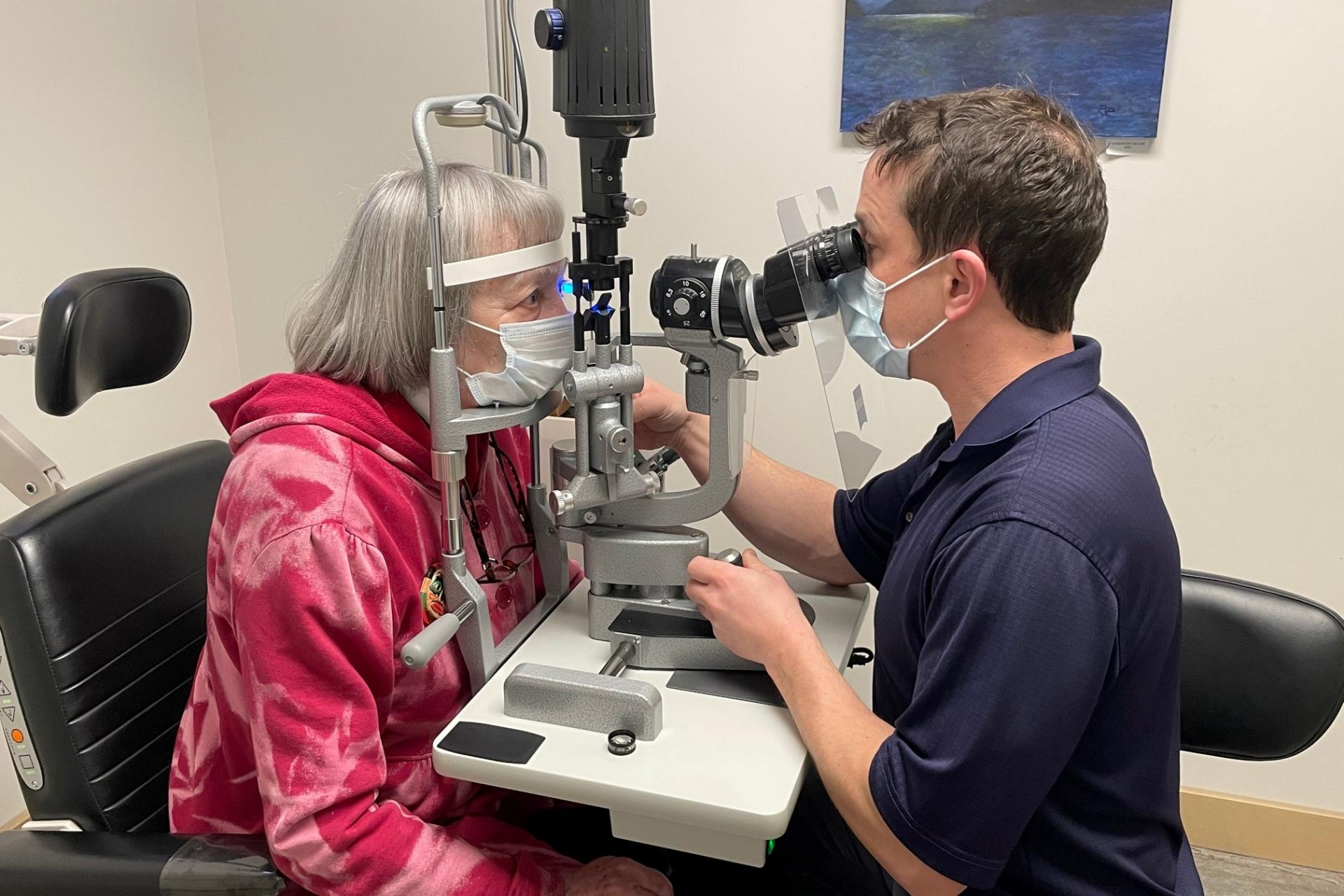 Dr. Brian Nelson with his slit lamp and a patient