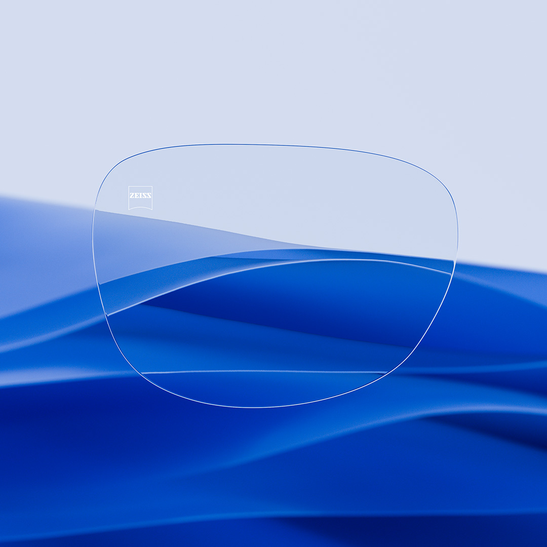 A split eyeglass lens with one side being clear and clean, featuring ZEISS DuraVision and one side with scratches covering the lens.