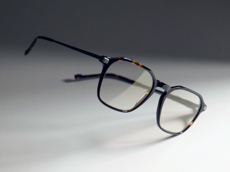 An image of clear eyeglasses in a brown frame with the subtle golden hue of ZEISS DuraVision Gold UV.