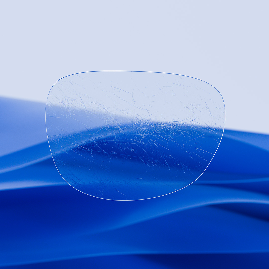 A split eyeglass lens with one side being clear and clean, featuring ZEISS DuraVision and one side with scratches covering the lens.