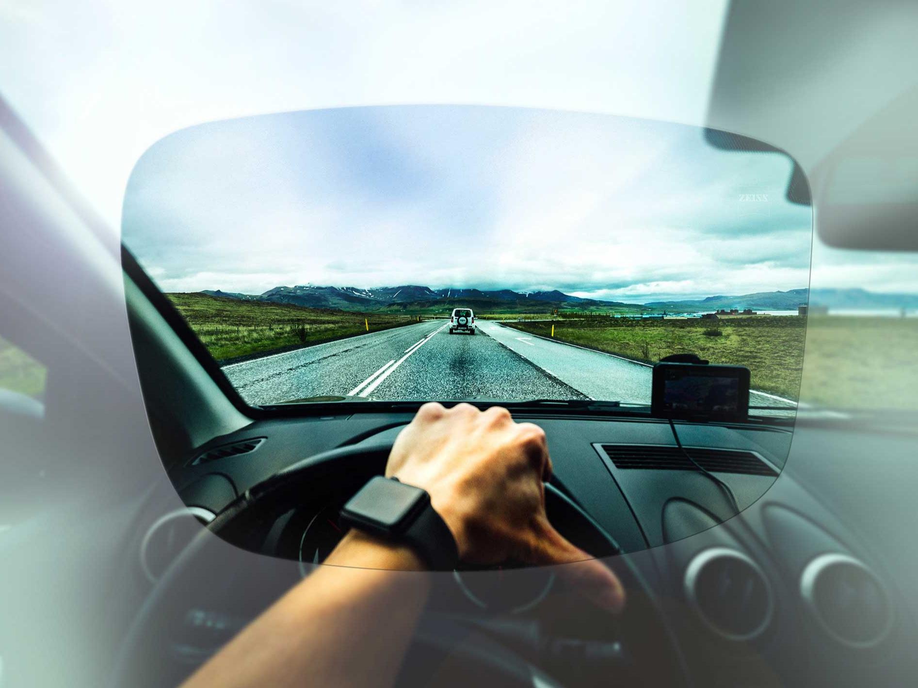 Clear view from the driver's perspective of a street and landscape through ZEISS lenses from the Drive Collection