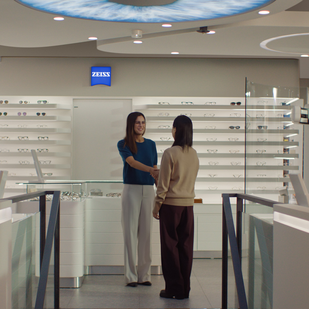 Deux femmes se serrent la main dans un magasin d’optique.