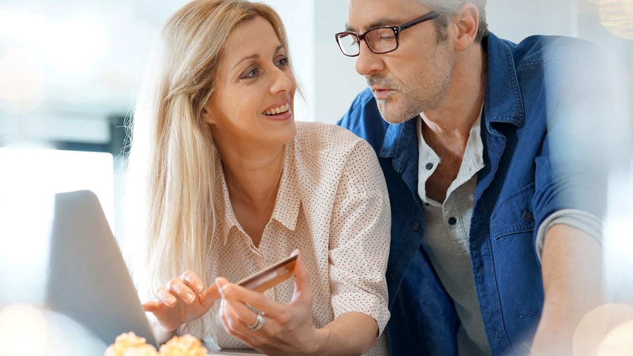 Middle-aged couple at home shopping on internet