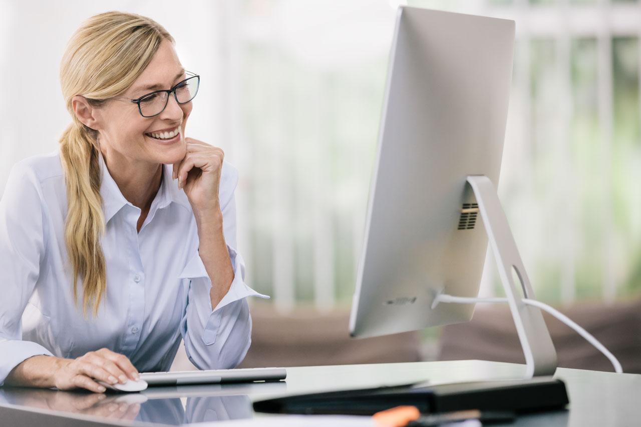 Femme regardant un écran d'ordinateur avec des lunettes