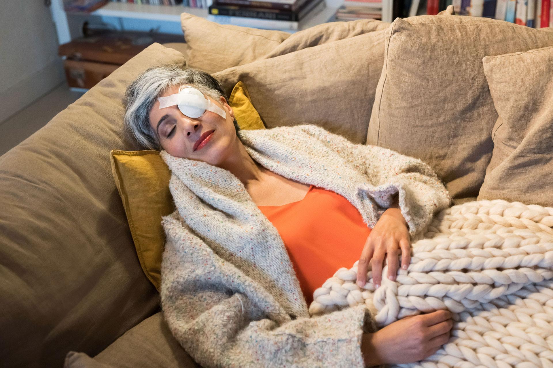 Patient with an eye patch resting after cataract surgery.