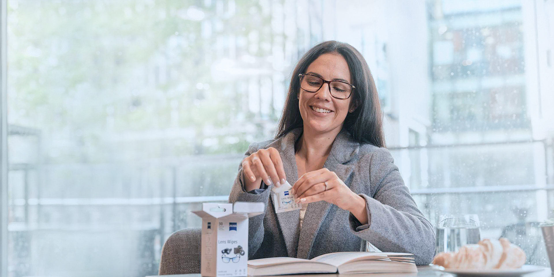 Femme ouvrant un sachet de lingettes nettoyantes pour verres de lunettes