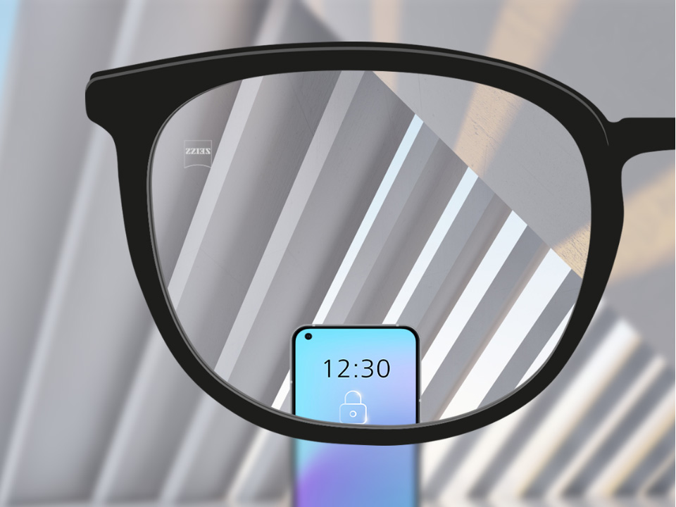 Illustration schématique du point de vue à travers un verre unifocal SmartLife qui montre des objets à distance et un smartphone clairement sans distorsion en périphérie. 