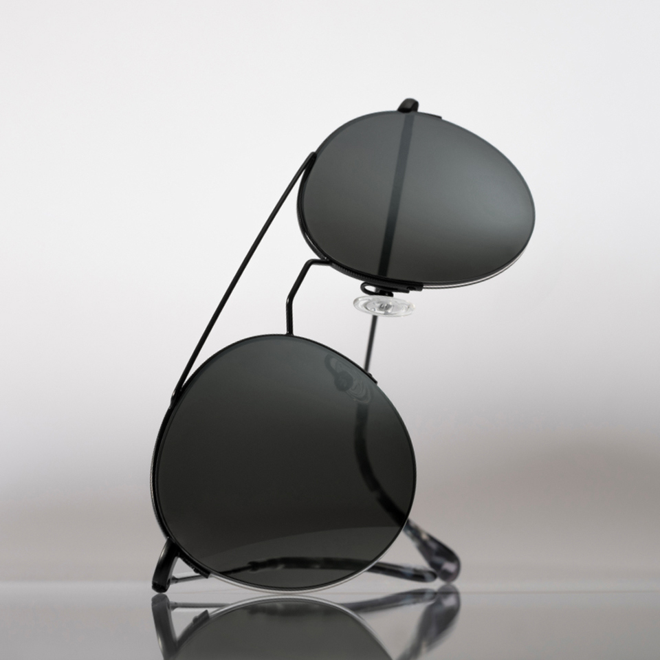 Des lunettes de soleil à teinte grise sont placées sur une surface claire et propre.